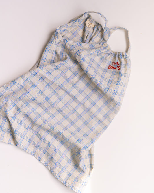 Blue and white checkered dress with 'The Bomb' logo on a white background