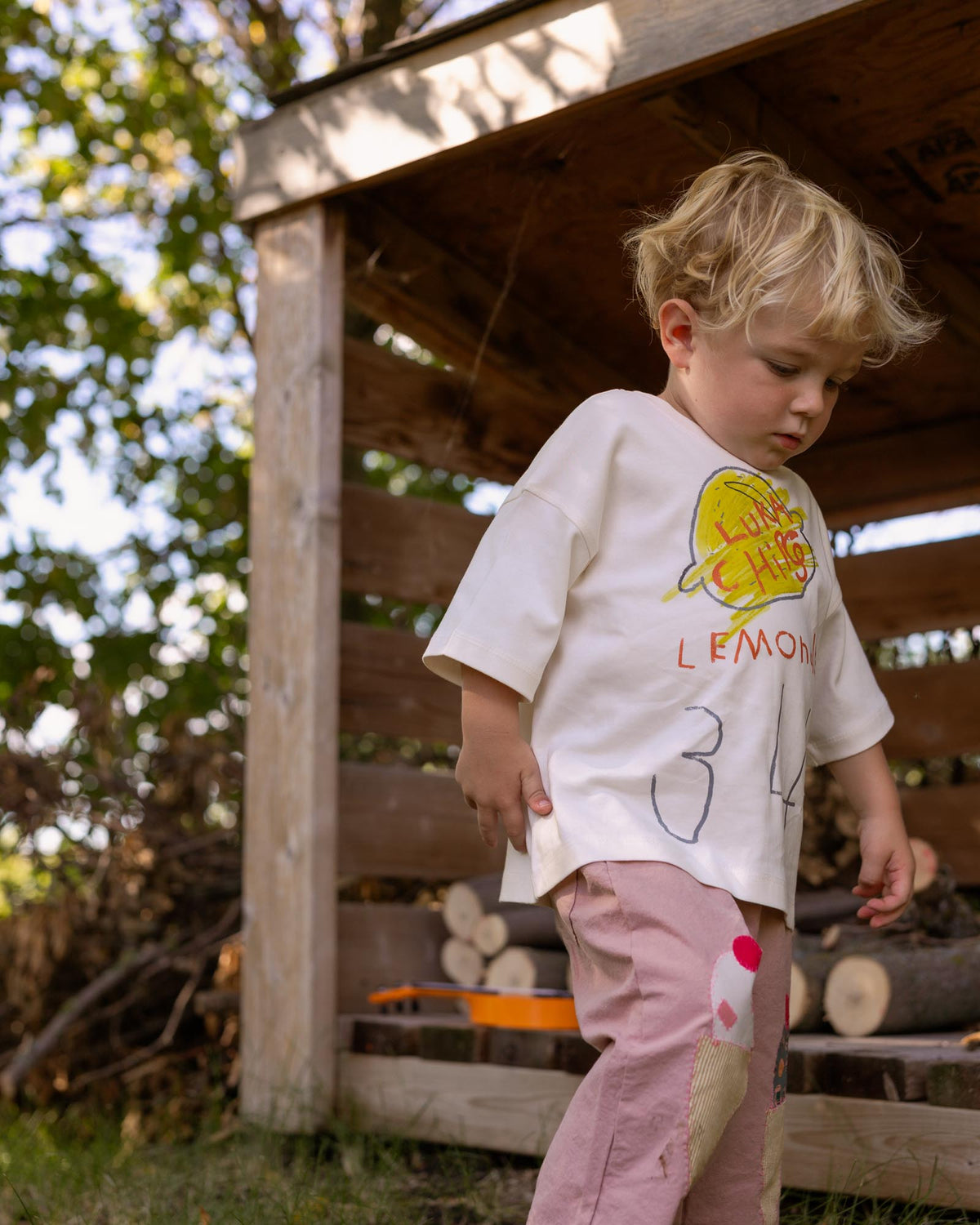 Kid wearing a lemon graphic tee with numbers.
