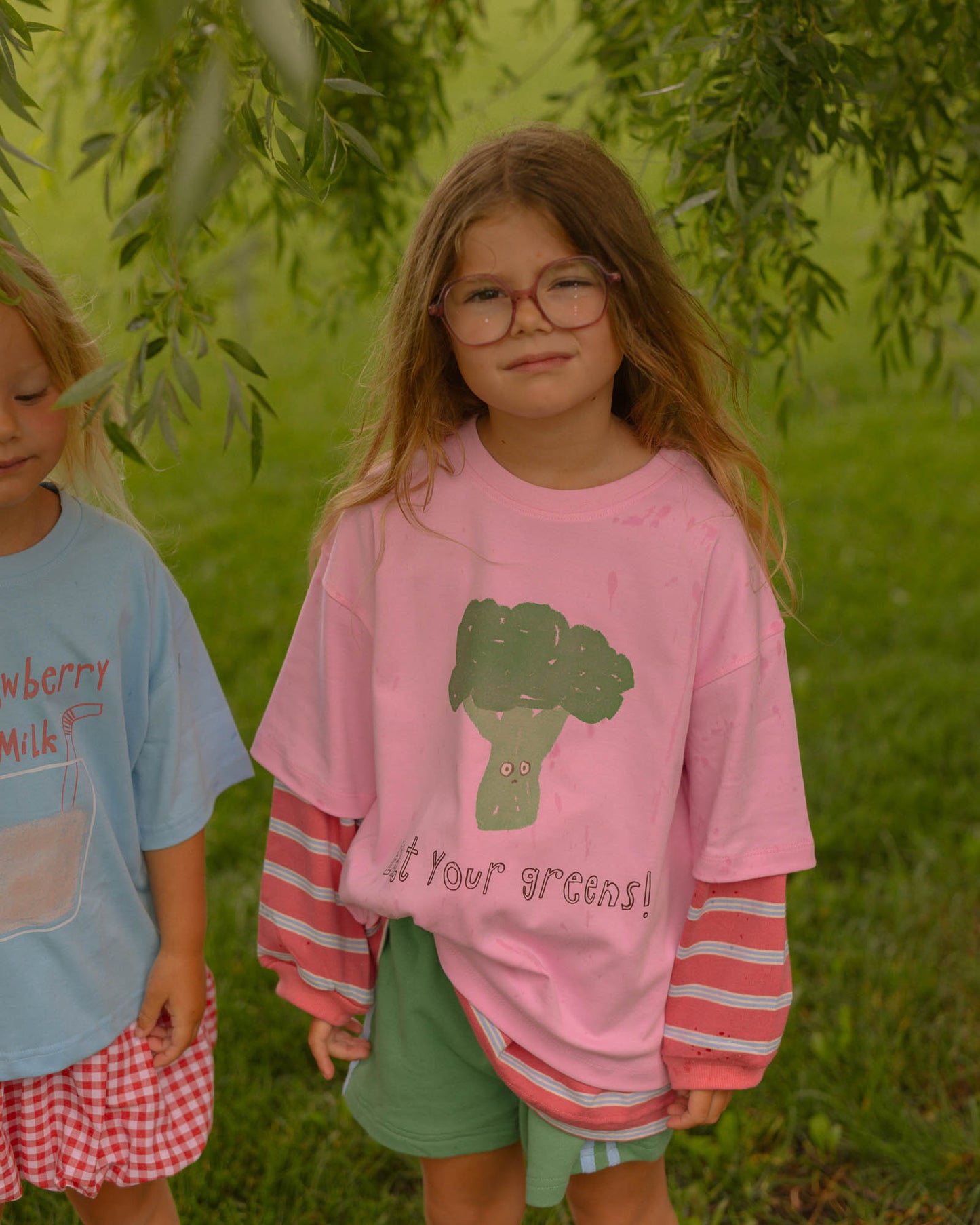 little girl wearing a pig and green outfit. layering kids clothes