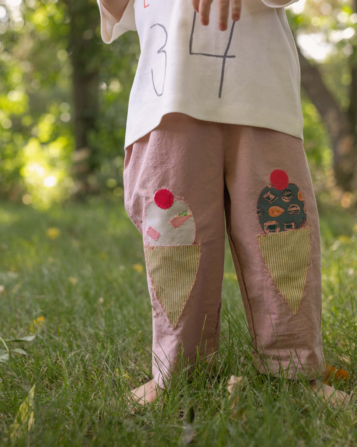 kid outside wearing plum pants with handsewn knee patches 