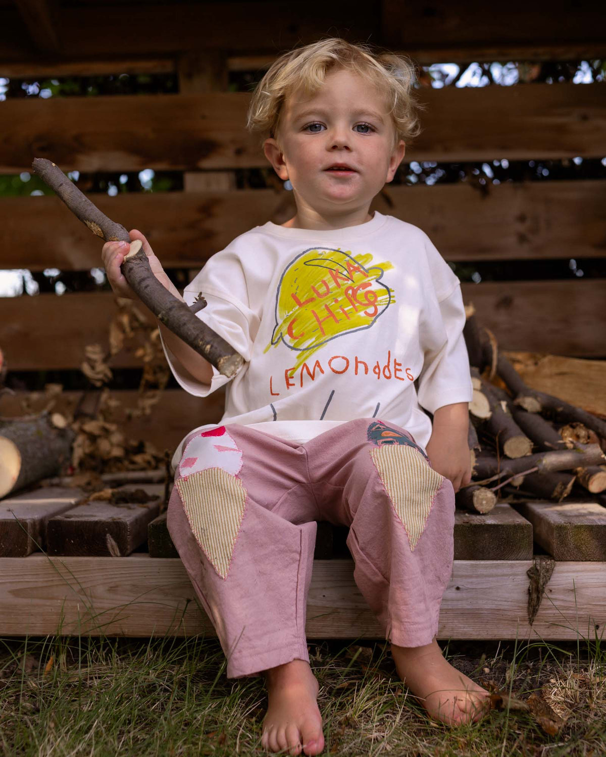 kid wearing washed purple pants with icecream patches sown on the knees. 