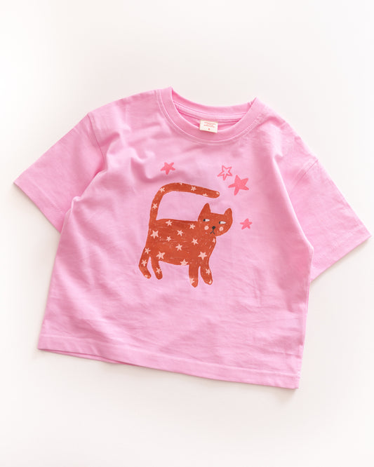 Pink t-shirt with a starry cat graphic on a white background